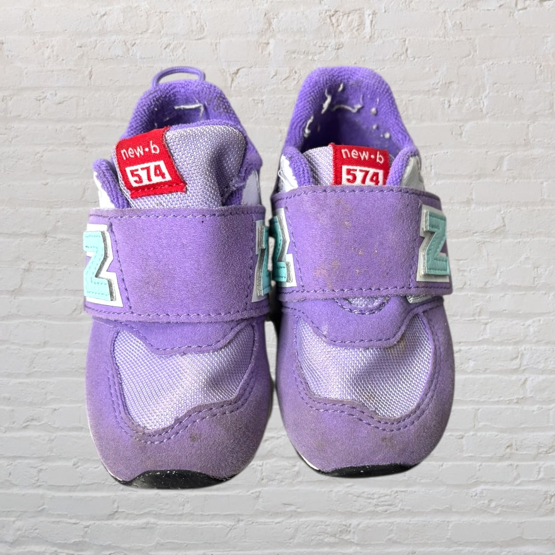 Purple New Balance 574 kids sneakers with aqua logo and Velcro straps.
