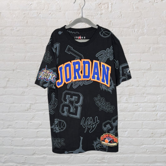 Black Jordan T-shirt with colorful logo and graphics, featuring bold lettering and various sporty designs.