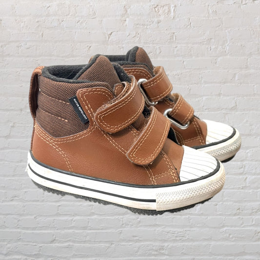 Brown high-top sneakers with Velcro straps and white rubber toe caps.