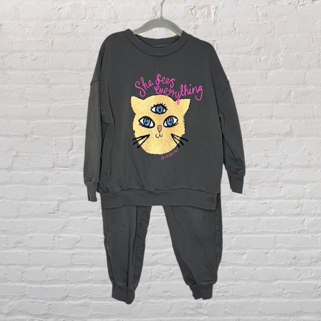 Charcoal sweatshirt and pants set featuring a cat graphic with three eyes and 'She Sees Everything' text by Mini Rodini.