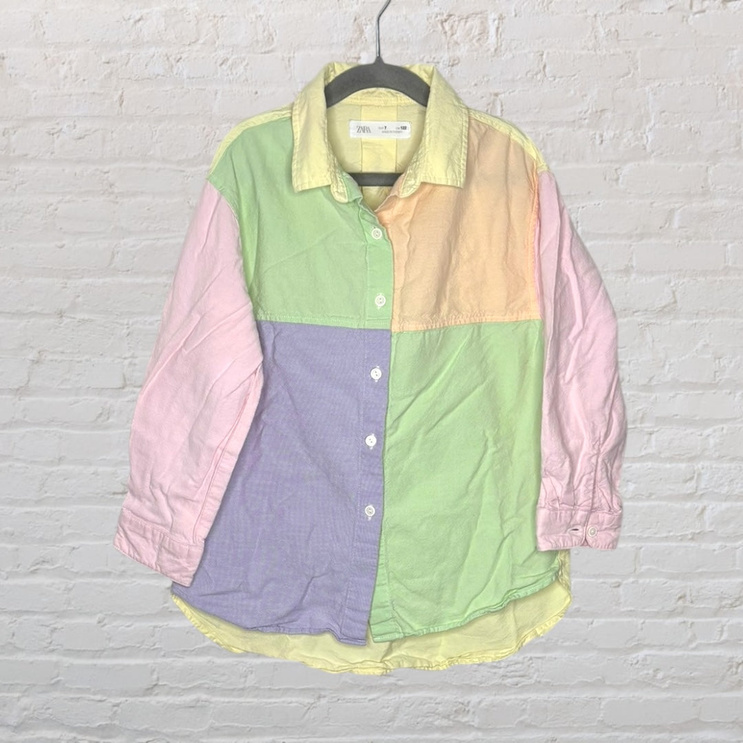 Colorful pastel patchwork button-up shirt with long sleeves and a collar, hanging on a hanger.