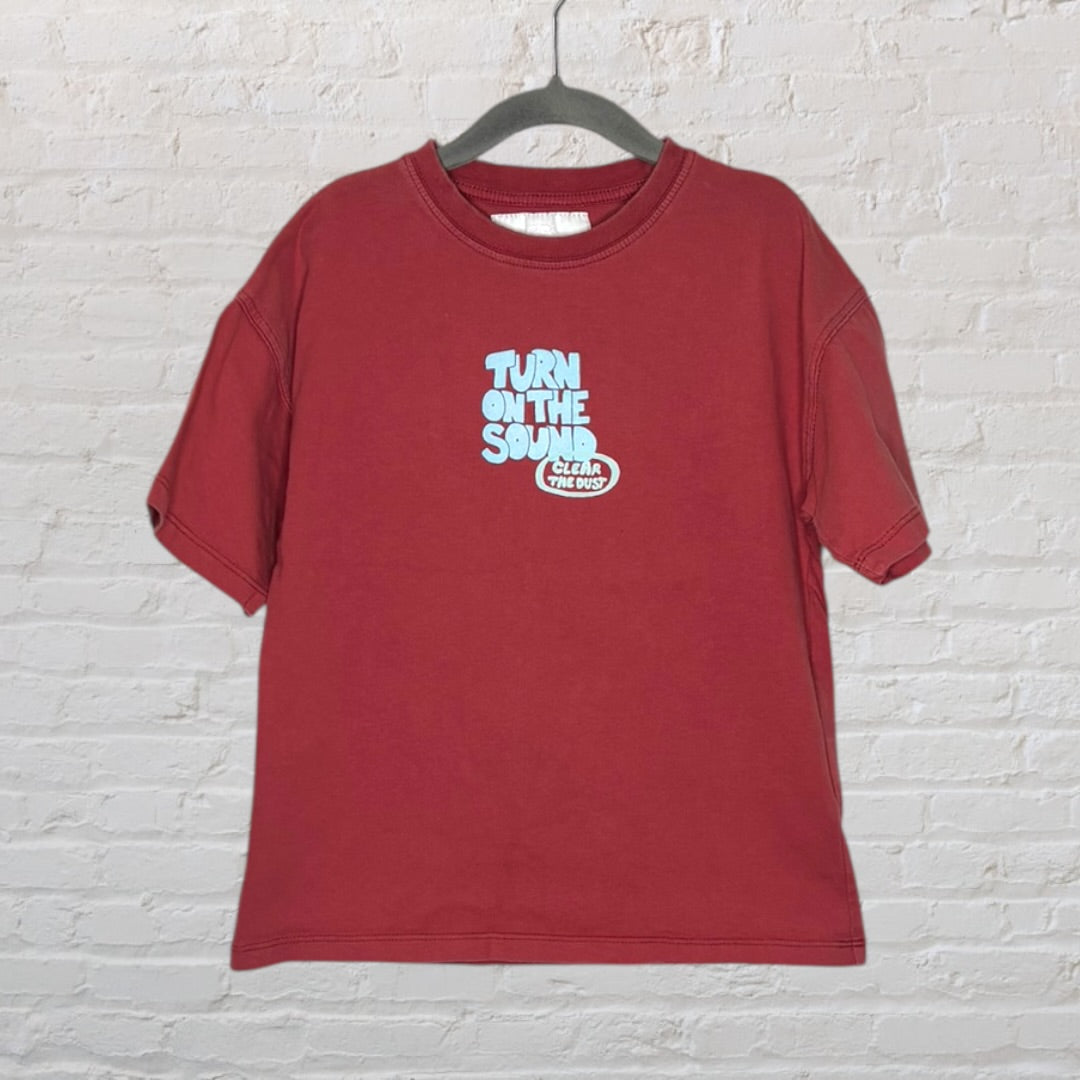 Red T-shirt with large blue and white text graphic 'Burn the Track' and motivational phrases, hanging on a hanger.