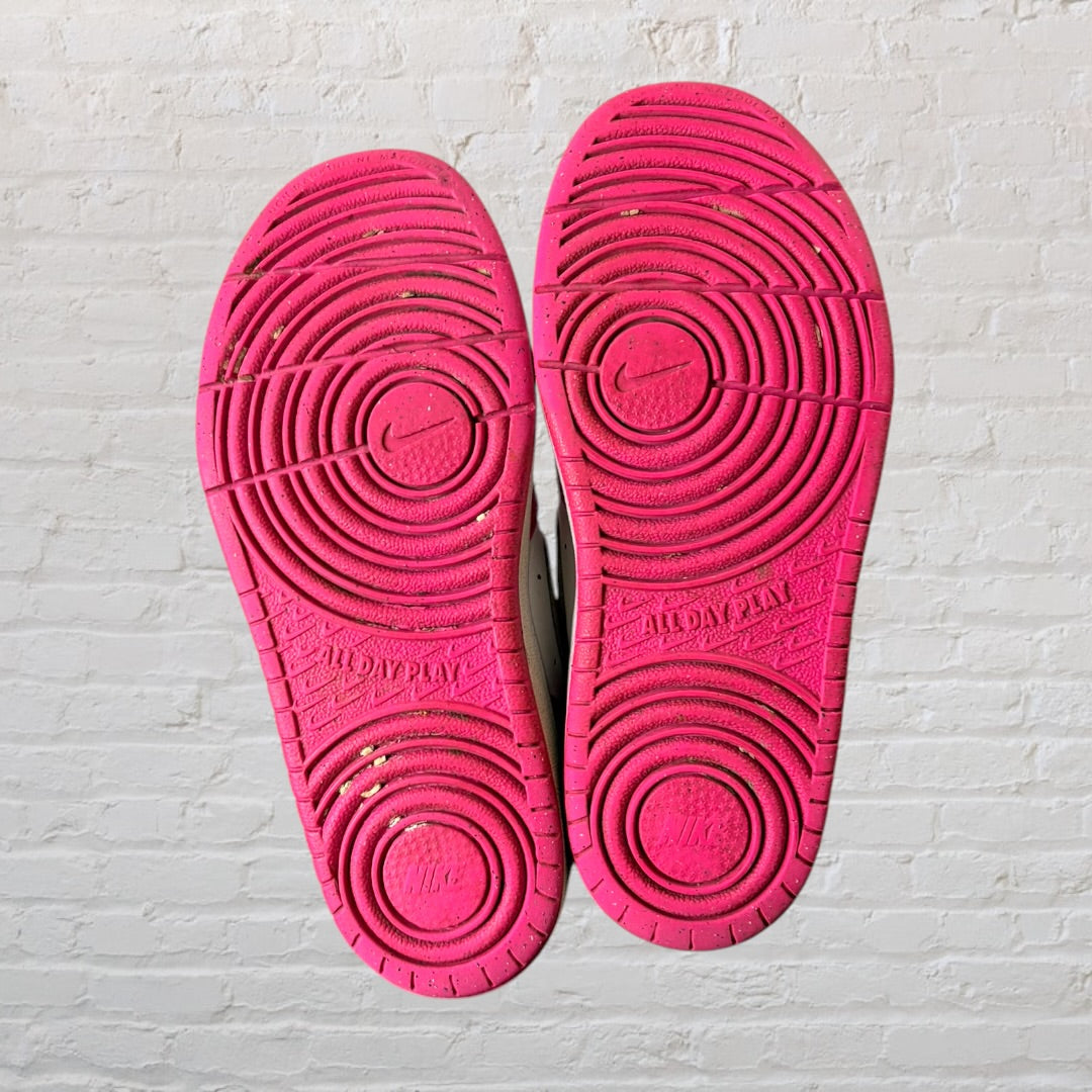 Pair of pink and white sneakers with Velcro straps and laces, showing some wear.
