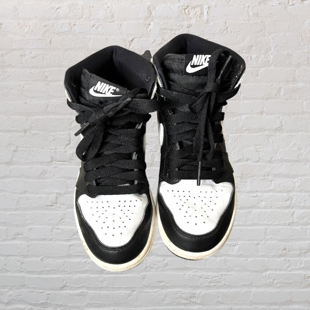 Black and white high-top sneakers with a distinctive swoosh logo and basketball emblem on the side.