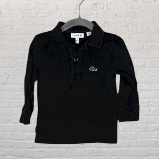 Black long sleeve Lacoste polo shirt with green crocodile logo on the chest, hanging on a hanger.