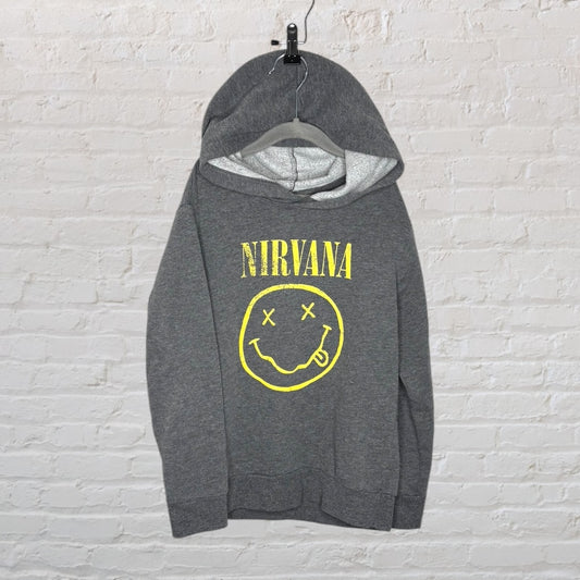 Grey Nirvana hoodie with yellow smiley face logo and text on a brick wall background.