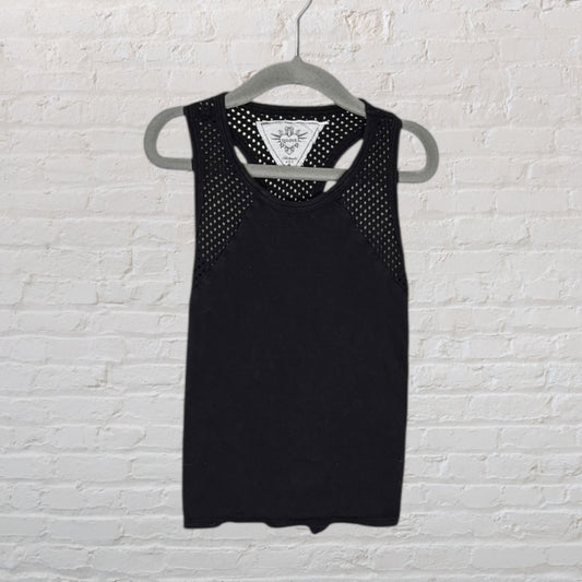 Black racerback tank top with perforated mesh details on the shoulders, hanging on a grey hanger.