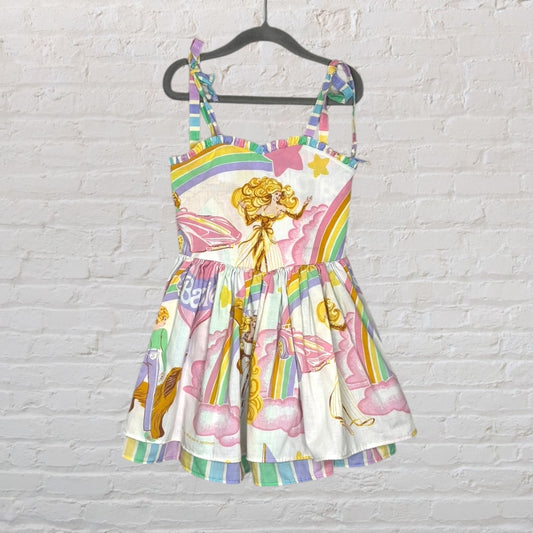 Colorful sundress with a Rainbow Brite theme, featuring rainbows and vibrant designs, hanging on a black hanger.