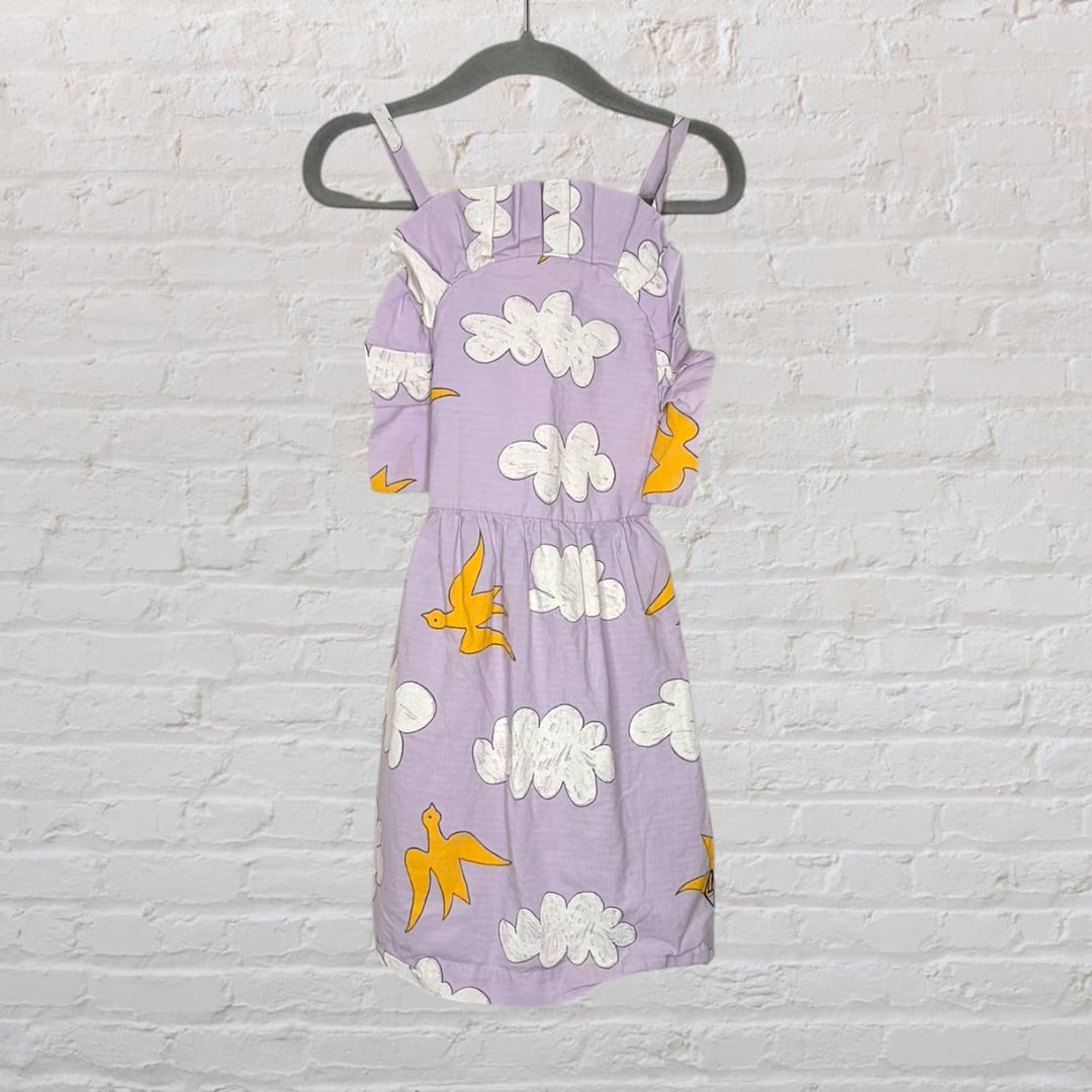 Lavender dress with white cloud and yellow bird print, featuring off-shoulder design with straps, hanging on a hanger.