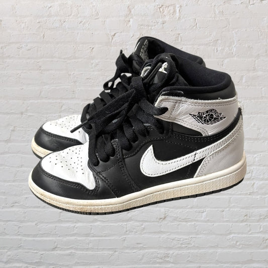 Black and white high-top sneakers with a distinctive swoosh logo and basketball emblem on the side.