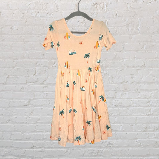 Peach skater dress with beach-themed prints including palm trees, suns, and vans, hanging on a hanger.