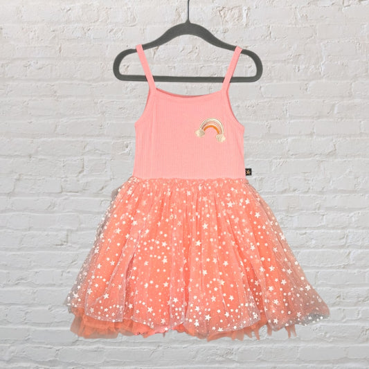 Peach dress with a rainbow patch and a starry tulle skirt, displayed on a hanger.