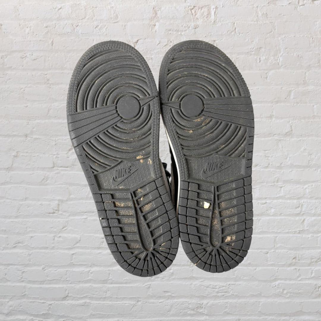 Black and white high-top sneakers with a distinctive swoosh logo and basketball emblem on the side.