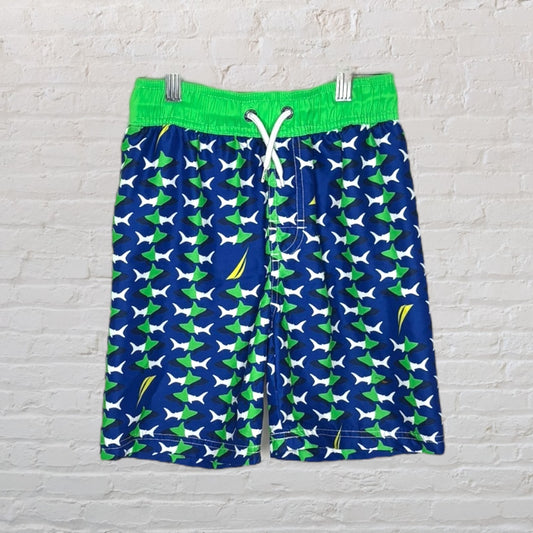 Blue swim shorts with green and white shark pattern and neon green waistband.