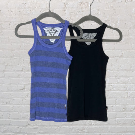 Set of two ribbed tank tops, one in blue stripe and the other in solid black, displayed on hangers against a brick wall.