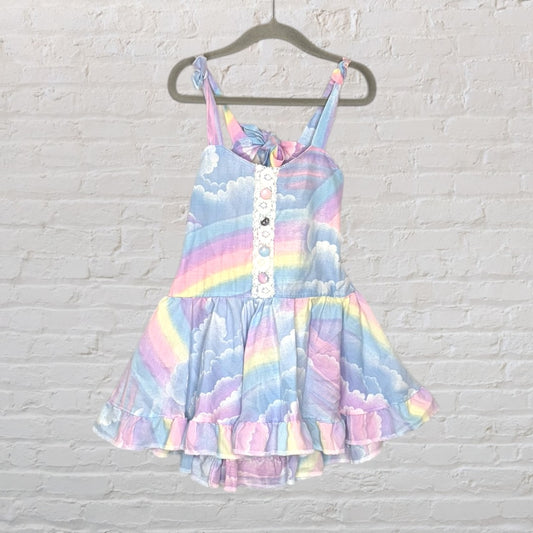 Children's dress with pastel rainbow and cloud print, featuring a ruffled hem and tied straps.
