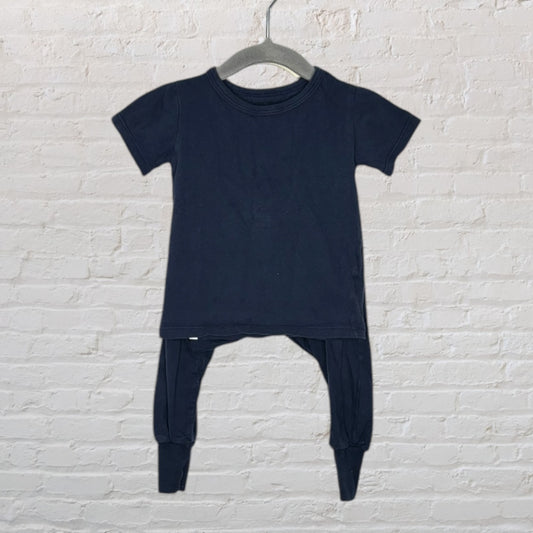 Unisex black two-piece outfit set consisting of a short-sleeve top and matching pants, hanging on a dark hanger.