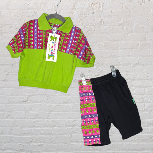 Vibrant Crosby outfit with a green polo shirt featuring a colorful dinosaur pattern and matching black shorts with side stripe.