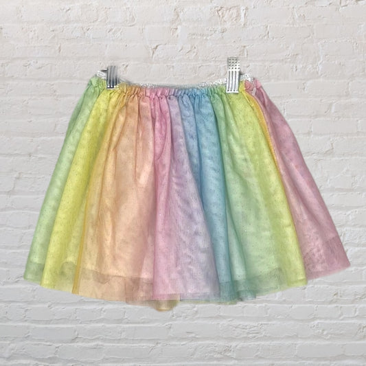 A pastel rainbow tulle skirt with soft colors including pink, blue, green, and yellow, displayed on a hanger.