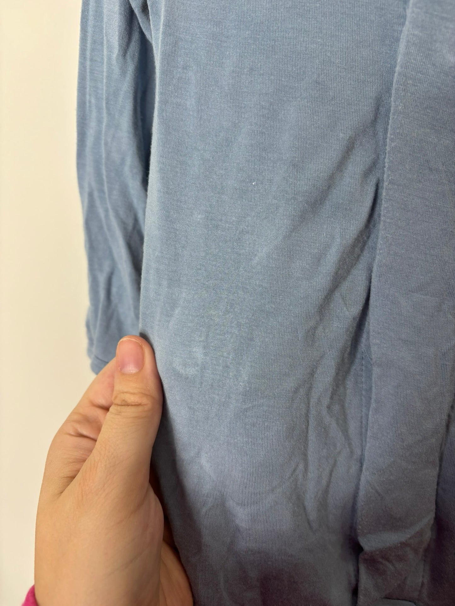 Blue baby footed sleeper with long sleeves displayed on a hanger.