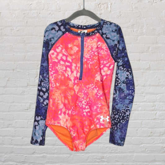 Under Armour rash guard with a bright pink and orange pattern and navy blue sleeves featuring floral prints, designed for swimwear.