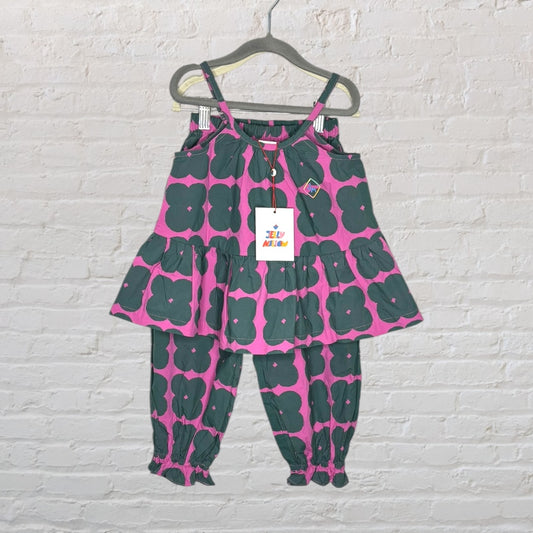 Pink and green floral outfit for kids with ruffle top and matching pants, hanging on a hanger.