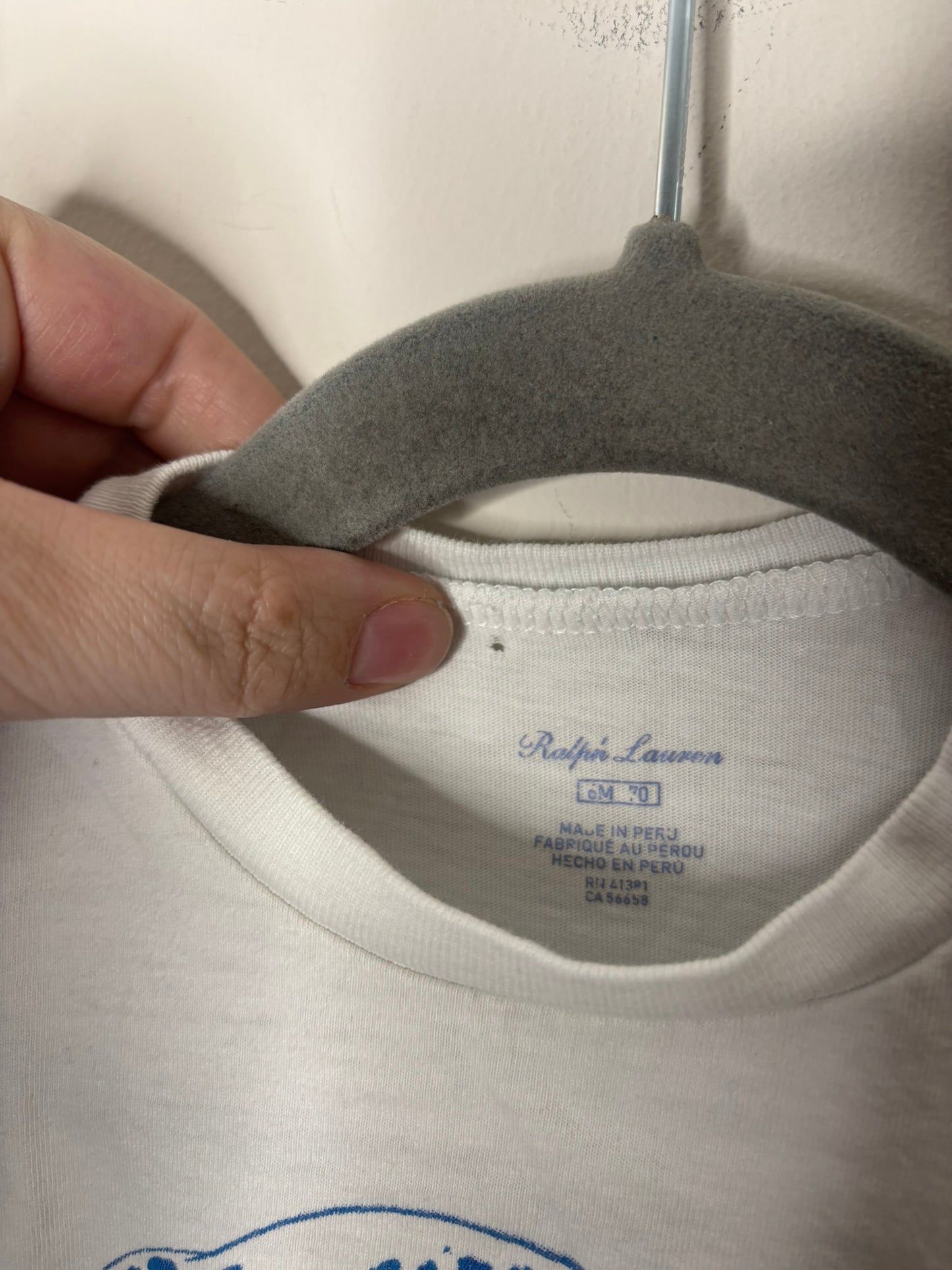 White Ralph Lauren T-shirt with a surfing Polo Bear graphic, featuring button details on the shoulder.