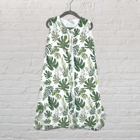 Unisex baby sleeping bag with green leaf pattern on a white background, hanging on a hook.