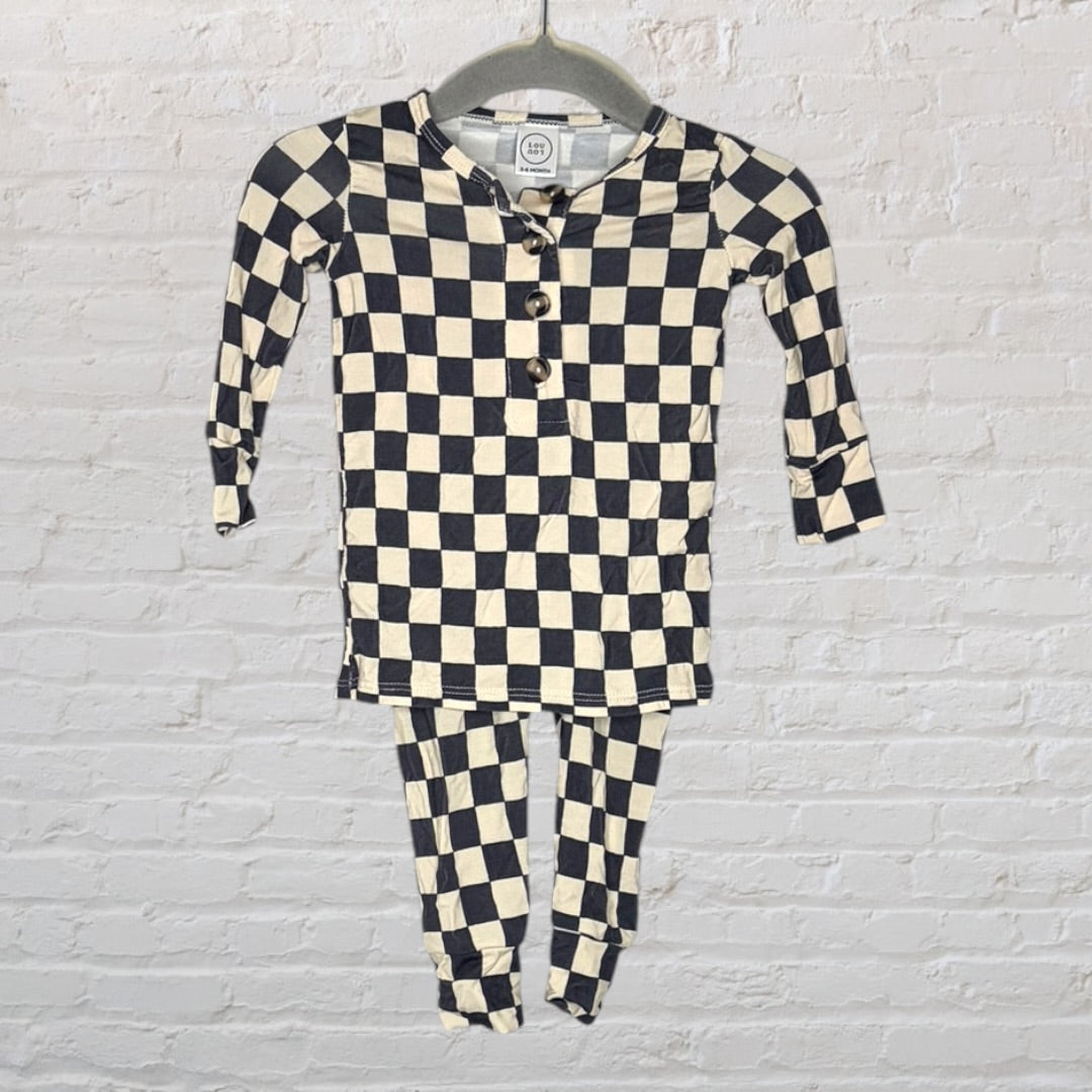 Black and cream checkered long sleeve pajama set with a henley neckline, hanging on a hanger.