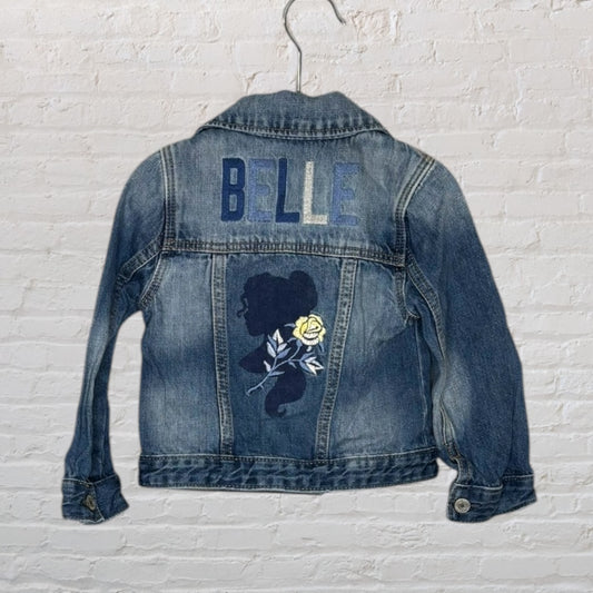 Blue denim jacket with 'Belle' embroidered on the back with a silhouette and rose design.