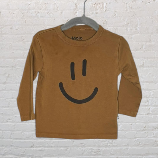 Brown long sleeve tee with a black smiley face design from Molo on a hanger.