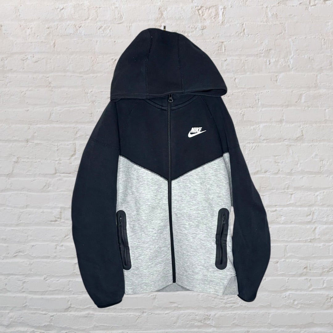 Nike two-tone black and grey hoodie with full zip and front pockets, featuring the Nike logo on the chest.
