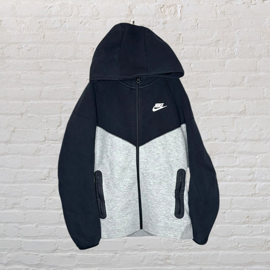 Nike two-tone black and grey hoodie with full zip and front pockets, featuring the Nike logo on the chest.