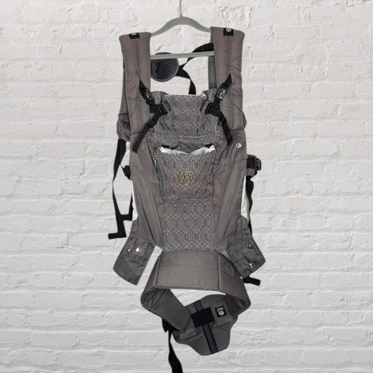 Gray ergonomic baby carrier with multiple straps and support, hanging on a hanger.