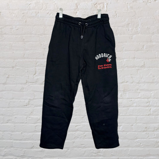 Black Hoodrich sweatpants with a graphic text design, featuring a drawstring waistband.