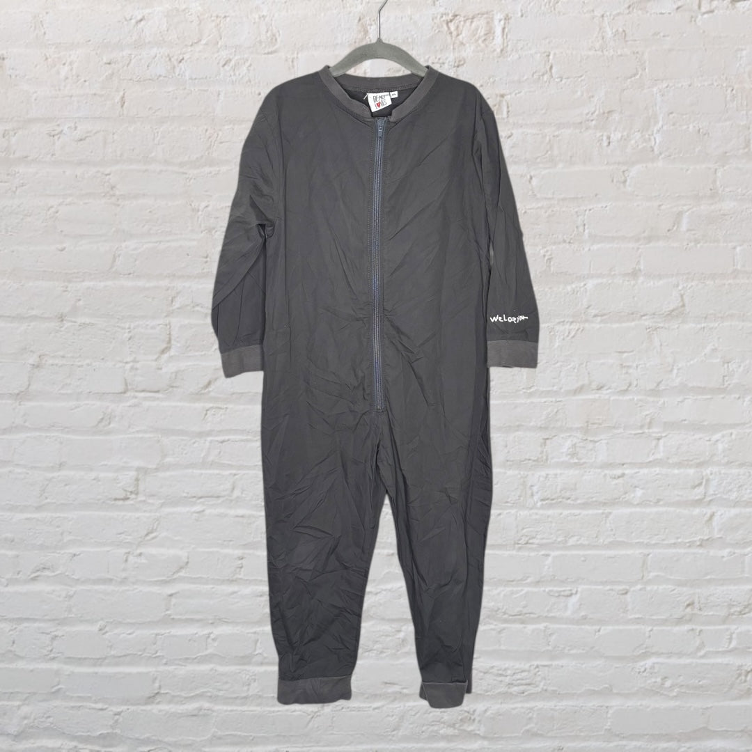 Dark grey coveralls with 'Hotel Cleaning Crew' printed on the back, displayed on a hanger against a white brick wall.