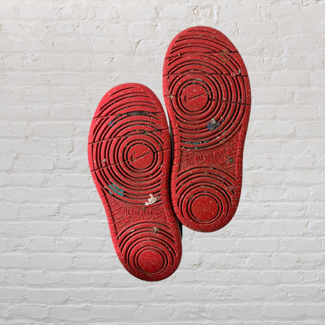 Pair of red and black low-top Nike sneakers with visible wear, Velcro straps, and laces.