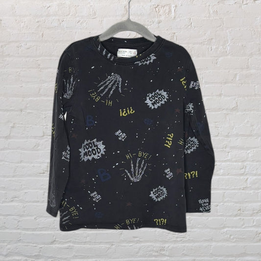 Black long sleeve shirt adorned with graphic prints including phrases like 'Cool Mood' and 'Hi-Bye!', hanging on a grey hanger.