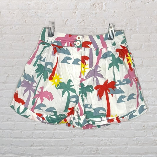 Colorful tropical print high-waisted women's shorts with palm trees and sun patterns, secured with button closure.