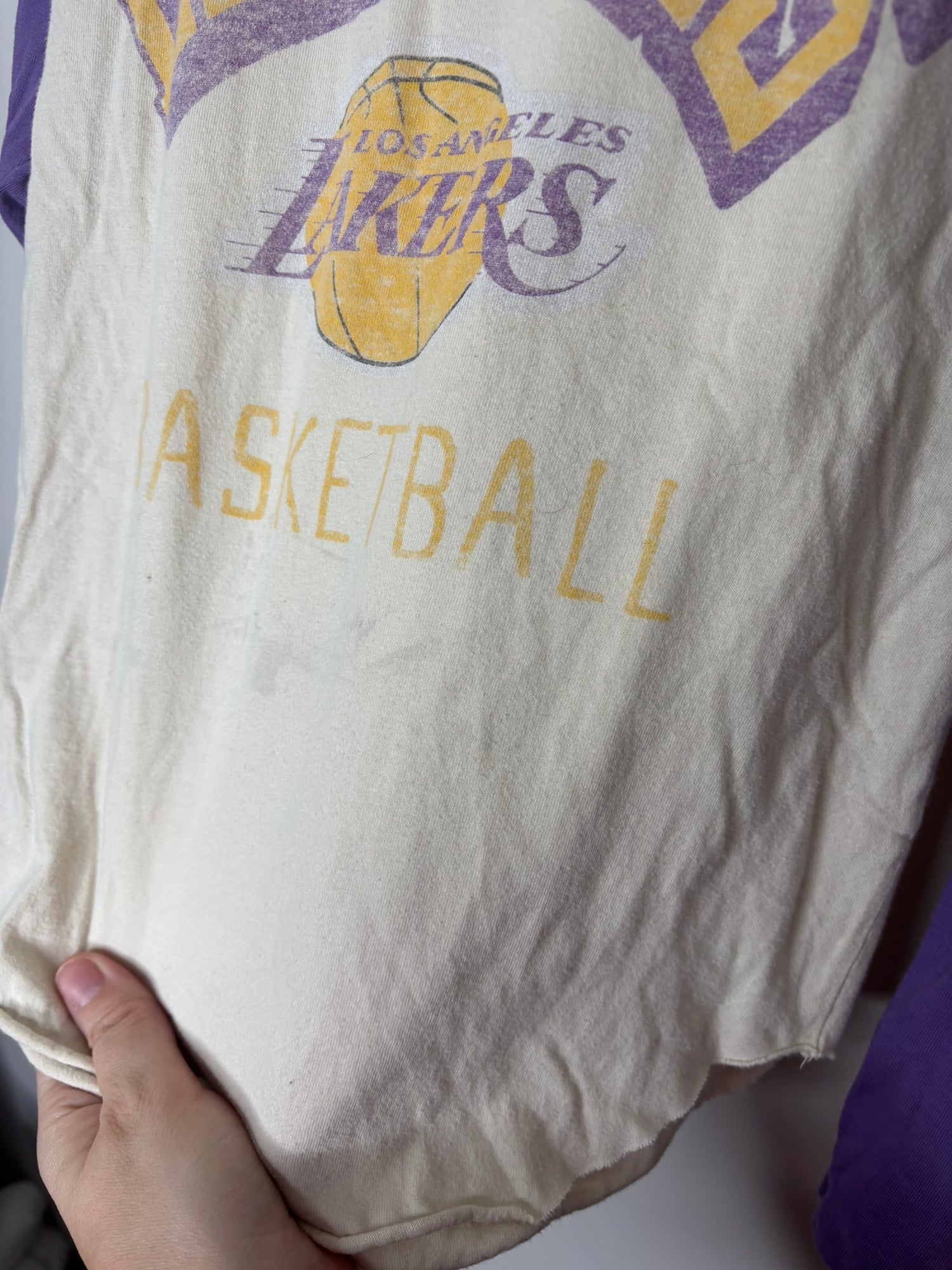 Los Angeles Lakers long-sleeve raglan tee with purple sleeves and cream body, featuring a vintage basketball graphic.