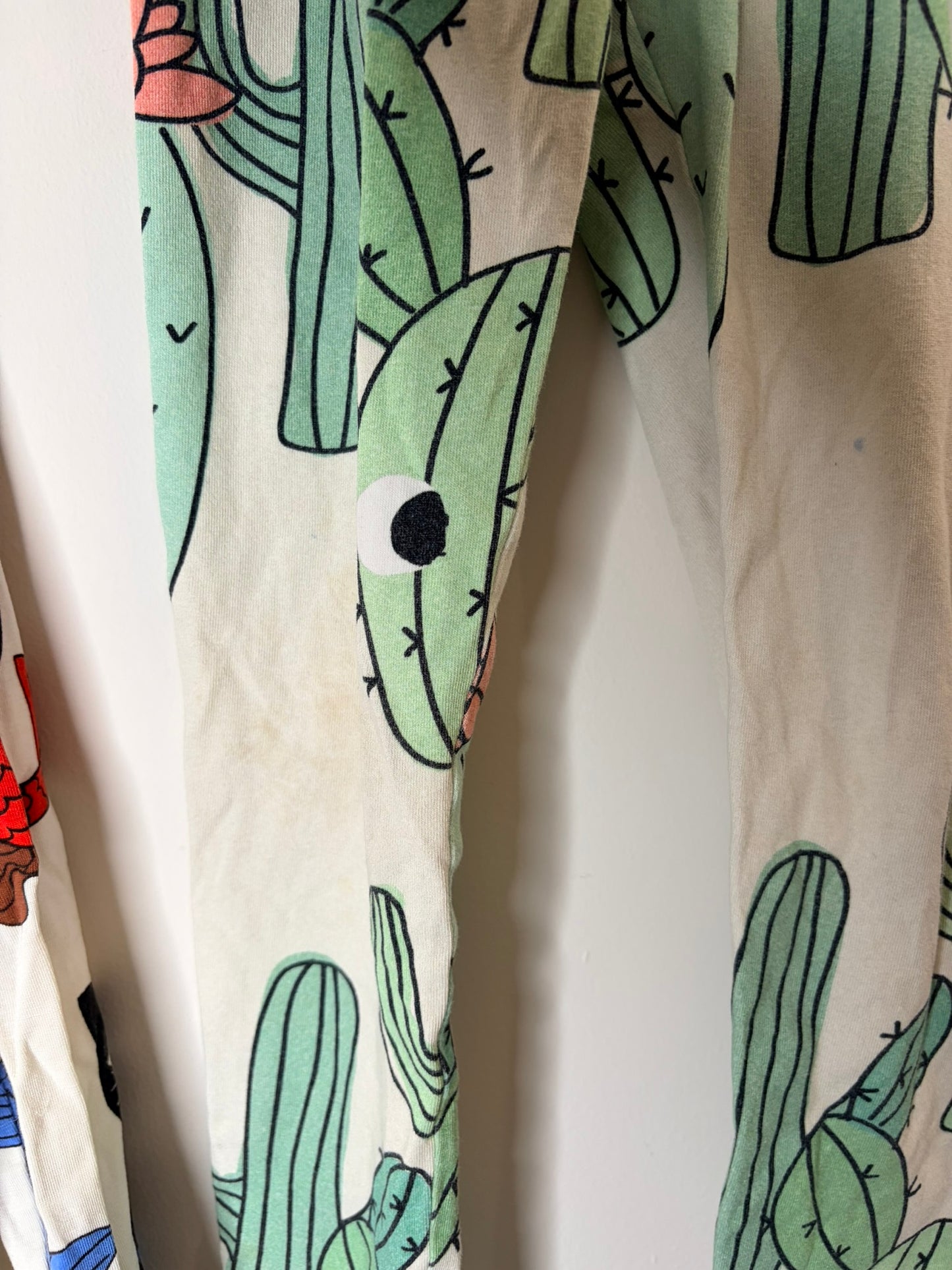 Multicoloured kids sleepwear set with various graphic designs including mermaids, cacti, and whimsical creatures.