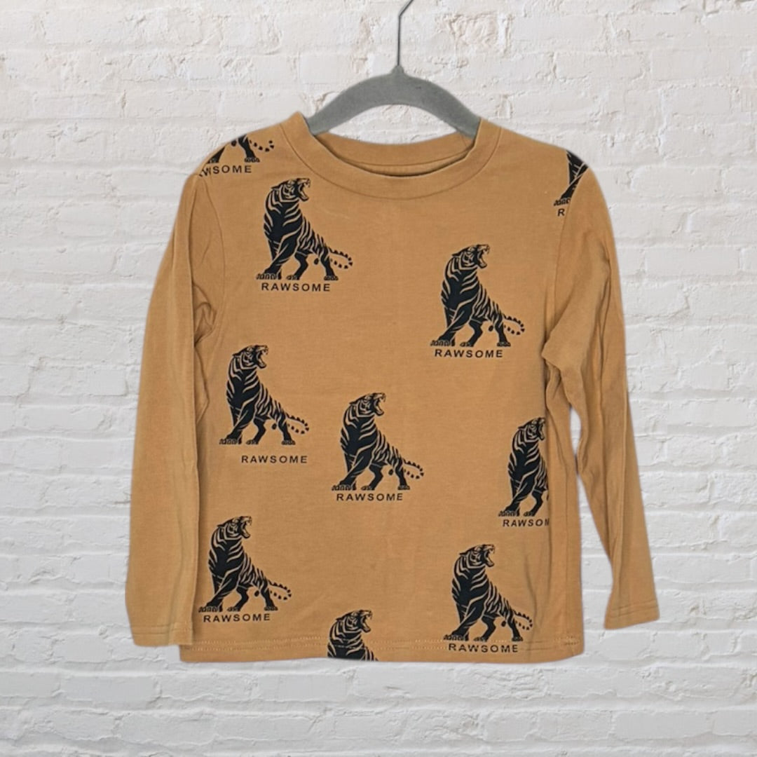Tan long sleeve shirt with black tiger graphic and 'Rawsome' text printed all over, hanging on a hanger.