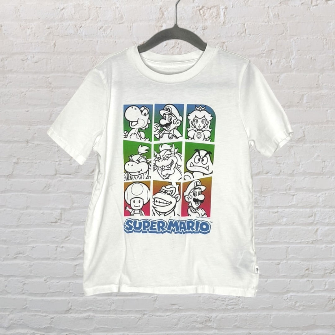 White T-shirt featuring Super Mario character graphics in a grid layout, hanging on a black hanger.