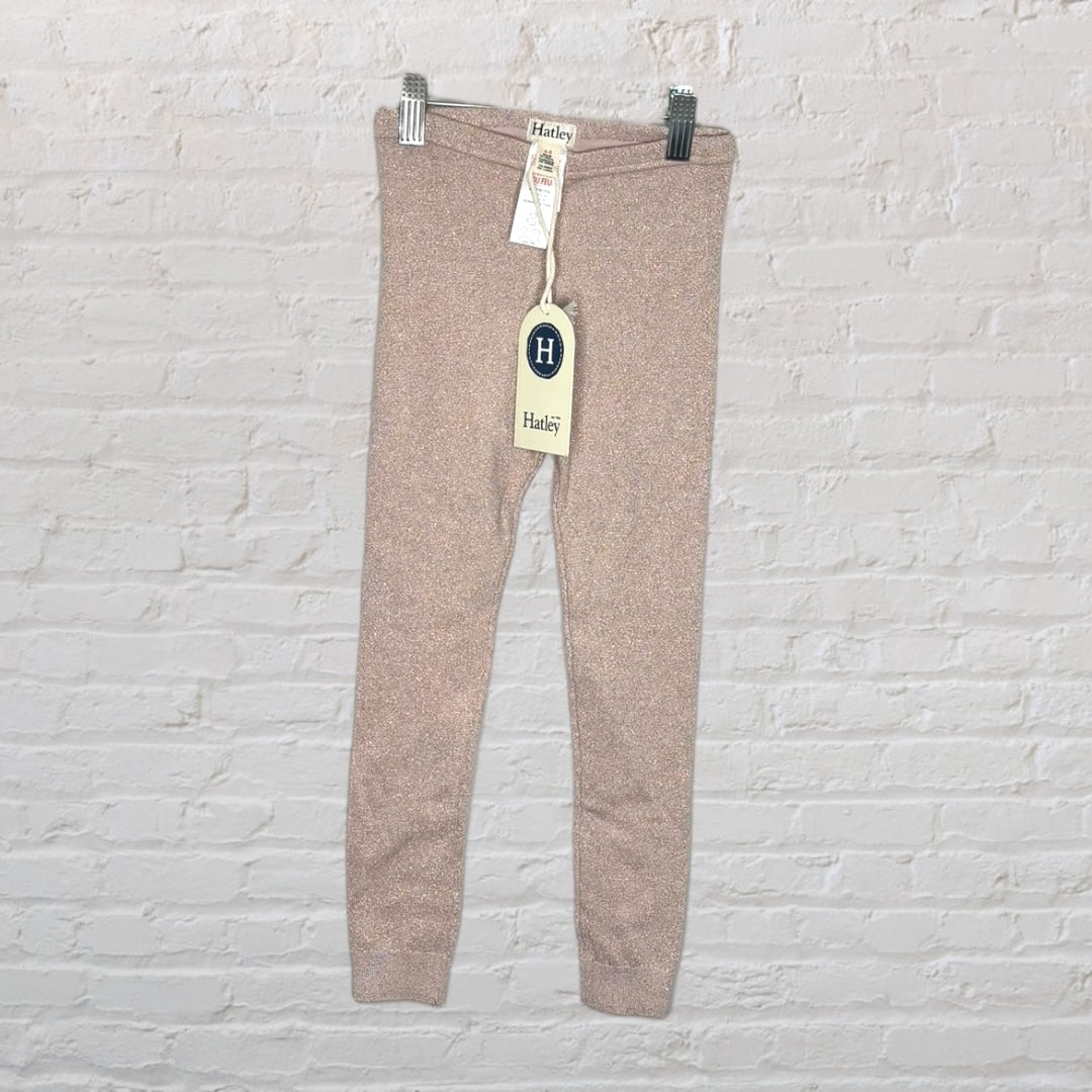 New Hatley sparkle leggings in pink with tags attached, displayed against a white brick wall.