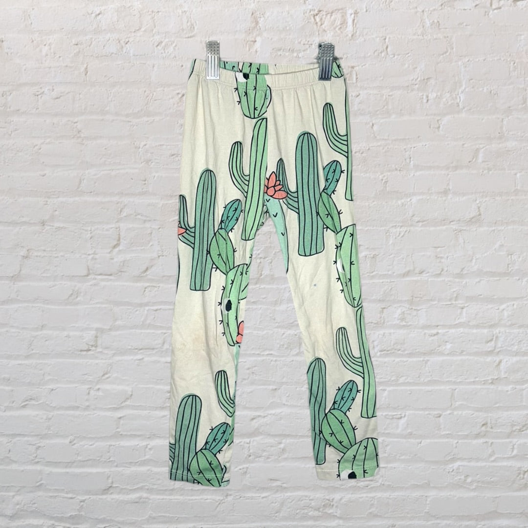 Multicoloured kids sleepwear set with various graphic designs including mermaids, cacti, and whimsical creatures.