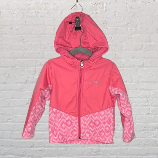 Pink Columbia hooded jacket with patterned sleeves and fleece interior, hanging against a brick wall.
