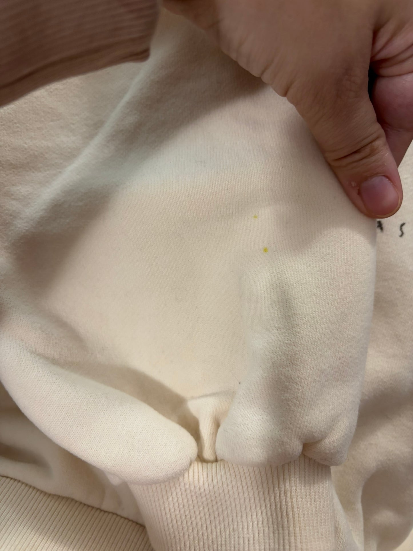 Cream sweatshirt with a cute bear in a stocking and 'Merry Christmas!' text, hanging on a hanger.