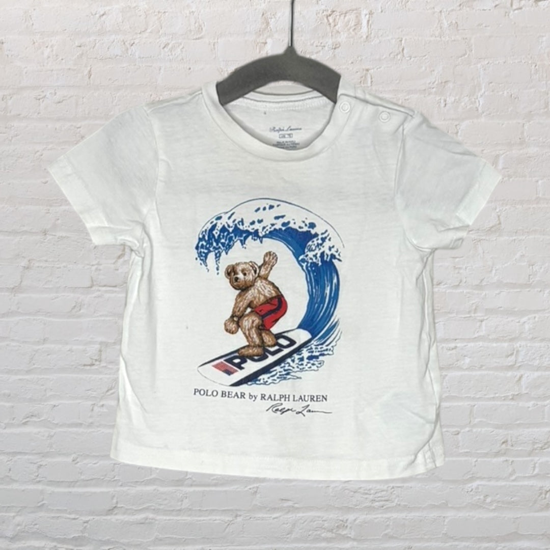 White Ralph Lauren T-shirt with a surfing Polo Bear graphic, featuring button details on the shoulder.