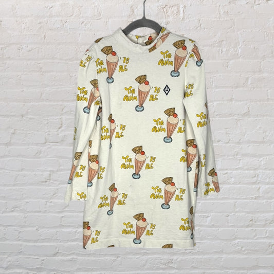 Cream long sleeve dress with colorful milkshake and text pattern, hanging on a hanger.