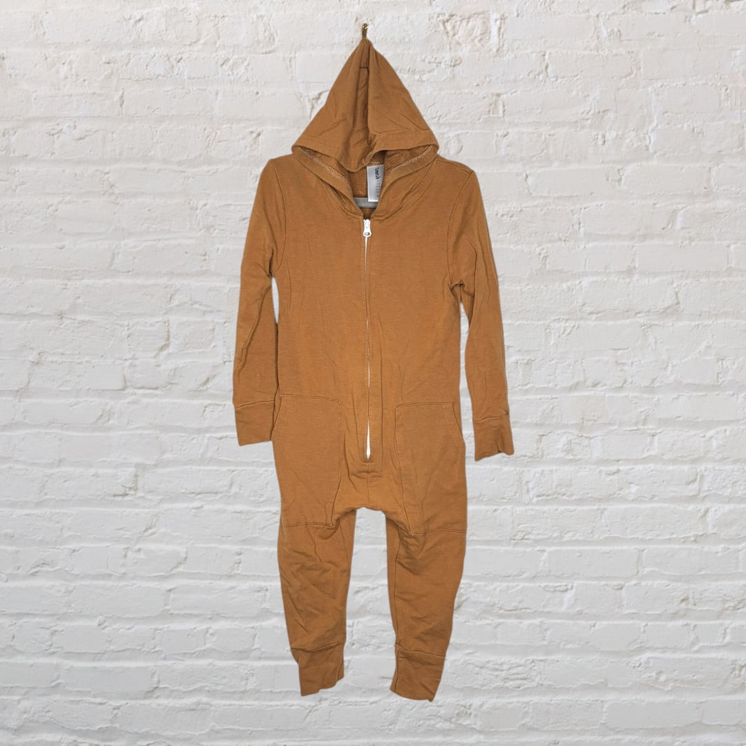 Brown hooded onepiece with a front zipper, designed for comfort, hangs against a white brick wall.